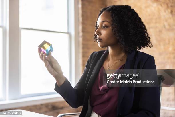 businesswoman examining prototype in modern conference room - intellectual property stock-fotos und bilder