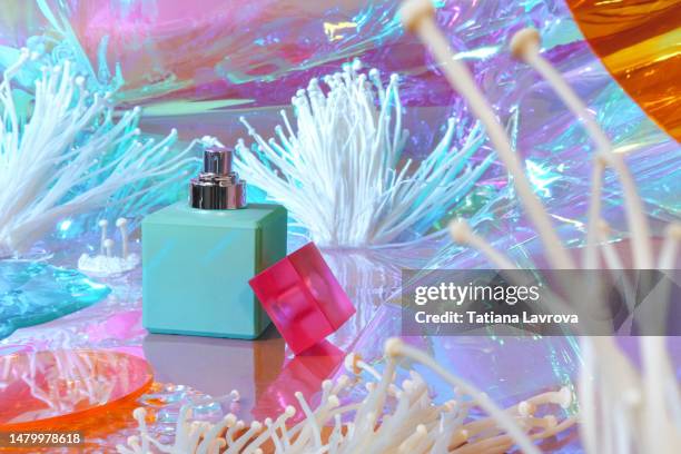 perfume bottle, enoki mushrooms and iridescent colored film. abstract psychedelic composition. bright, extraordinary backdrop for beauty products, pills, drugs. surreal futuristic background - scent diffuser stock pictures, royalty-free photos & images