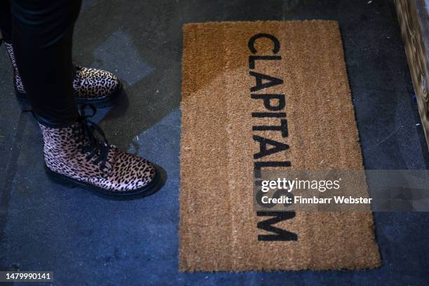 Doormat reading 'Clapitalism' in a reference to Clap for Carers and capitalism, is seen at the Revolting Artists exhibition, on April 05, 2023 in...