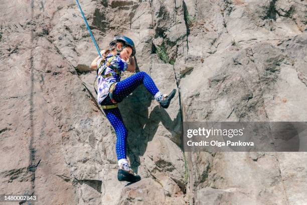 young girl is climbing to the top of a mountain - sport climbing stock pictures, royalty-free photos & images