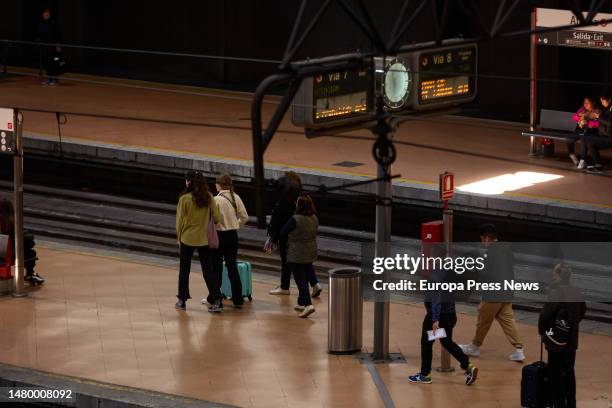 Several people wait for the arrival of a commuter train at Almudena Grandes-Atocha Cercanias station, April 5 in Madrid, Spain. Renfe is offering...