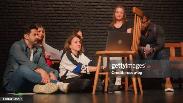 group of theater stage performers using laptop to check and watch their former plays - improvisatie stockfoto's en -beelden