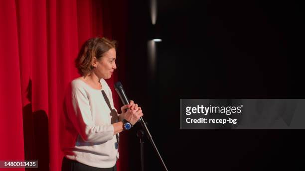 female director talking to audiences and introducing performance and play on stage - woman comedian stock pictures, royalty-free photos & images