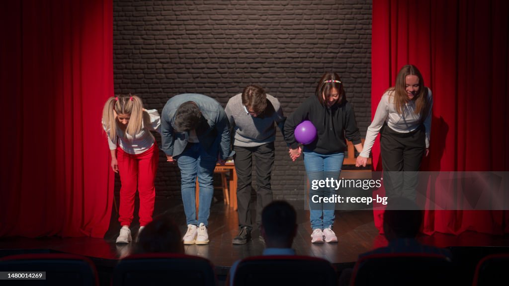 Group of theater stage performers bowing in front of audiences on stage