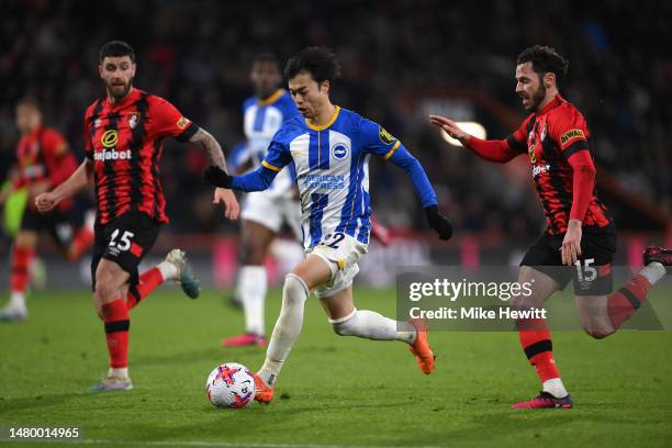 Kaoru Mitoma of Brighton & Hove Albion gets away from Marcos Senesi and Adam Smith of Bournemouth during the Premier League match between AFC...