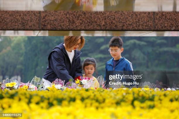 People present flowers to a monument at a martyrs cemetery for the Qingming festival on April 05, 2023 in Shanghai, China.
