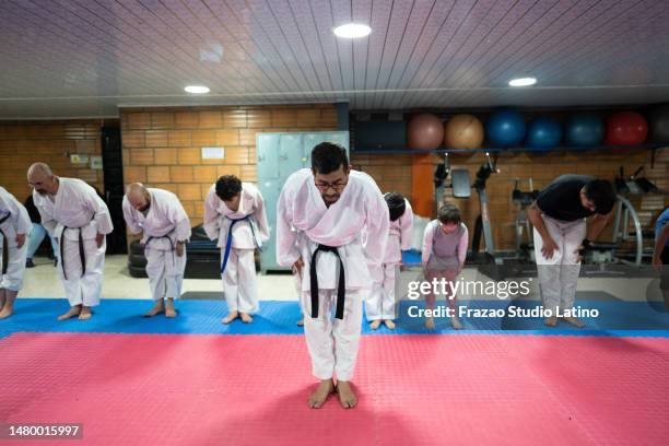 sensei e studenti che si inchinano durante una lezione di karate - karate foto e immagini stock