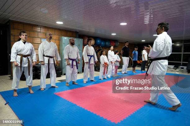 sensei talking with students during a karate class - karate master stock pictures, royalty-free photos & images