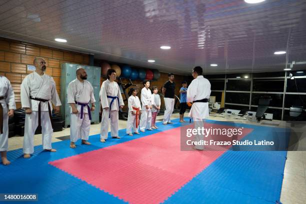 sensei talking with students during a karate class - zwarte band stockfoto's en -beelden