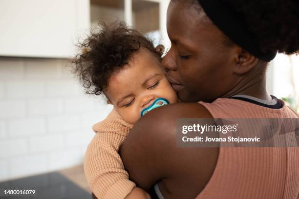 mutter zeit mit ihren babys – jungen - black mother holding newborn stock-fotos und bilder