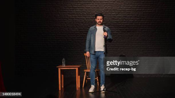 portrait of a male stand-up comedian talking on stage - stand up comedy stockfoto's en -beelden