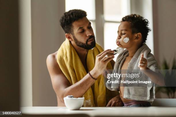 young father showing his little son how to shave. - fathers day stock pictures, royalty-free photos & images