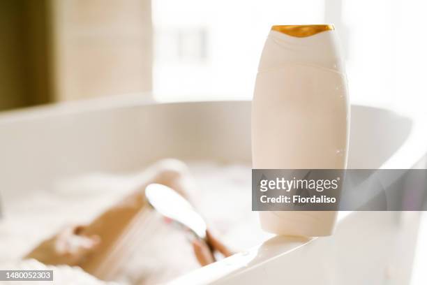 woman taking a bubble bath. relaxation and beauty treatments. natural beauty, daily skincare routine. moisturizing, cleansing - bubble bath bottle stock pictures, royalty-free photos & images