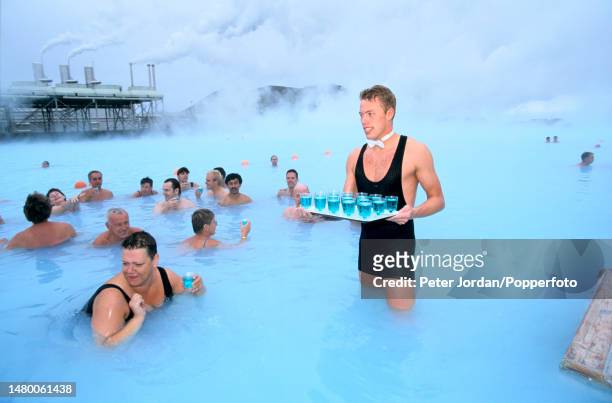 Bathers are served drinks by a waiter in the hot water pools of the Blue Lagoon, a geothermal spa near the town of Grindavik in southwestern Iceland...