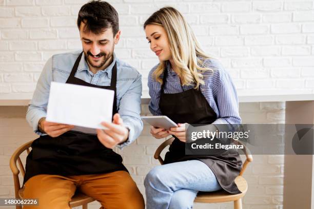 team of waiters working at a restaurant and looking at the menu- food service occupation concepts - pub reopening stock pictures, royalty-free photos & images