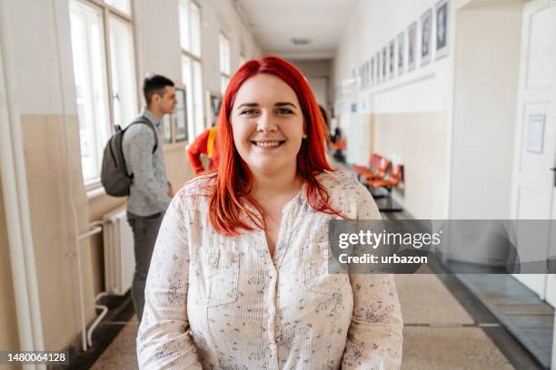 young female student in a school hall - dyed red hair 個照片及圖片檔