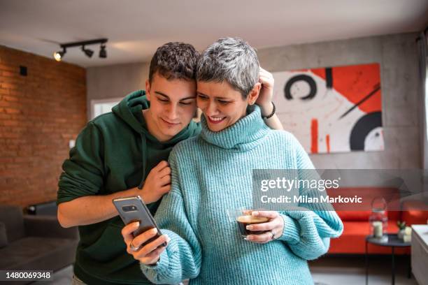 madre e hijo adolescente abrazándose - padre e hijas fotografías e imágenes de stock