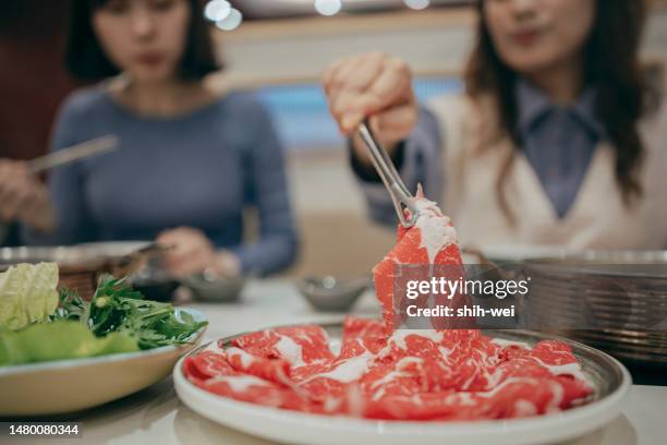 two taiwanese women went to a restaurant together to enjoy chinese hot pot. - hot pots stockfoto's en -beelden