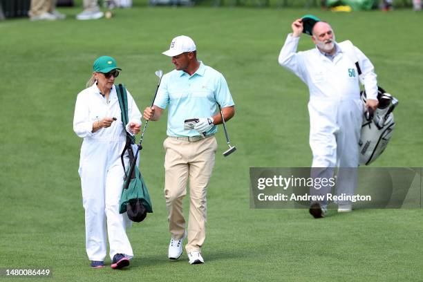 Bryson DeChambeau of the United States walks down the fairway with his mother, Jan DeChambeau, during the Par 3 contest prior to the 2023 Masters...