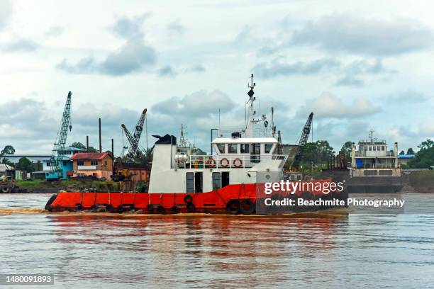 red and white tugboat passing through the  rajang river at the waterfront in sibu, sarawak, malaysia - sibu river stock pictures, royalty-free photos & images