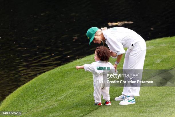 Harold Varner III of the United States wife, and son Liam walk on the ninth green during the Par 3 contest prior to the 2023 Masters Tournament at...