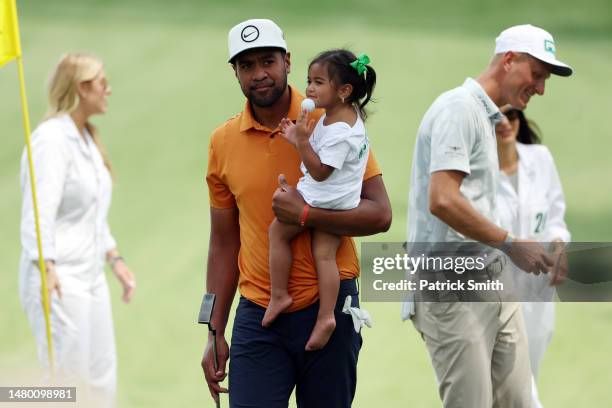 Tony Finau of the United States looks on with his daughter Sienna-Vee Finau during the Par 3 contest prior to the 2023 Masters Tournament at Augusta...