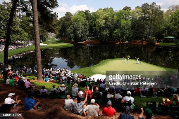 Patrons watch the ninth green as Gary Woodland of the United States celebrates a putt during the Par 3 contest prior to the 2023 Masters Tournament...