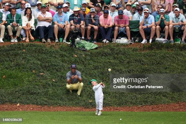 Billy Horschel of the United States son Axel Brooks plays his shot from the ninth tee during the Par 3 contest prior to the 2023 Masters Tournament...