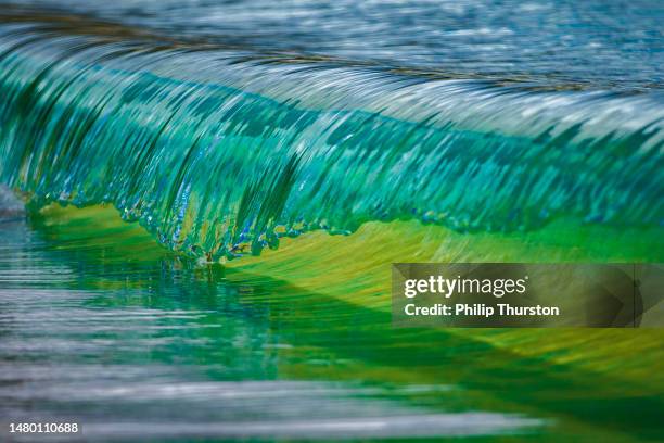 miniature macro wave breaking on shoreline with stunning detail - emerald green stock pictures, royalty-free photos & images