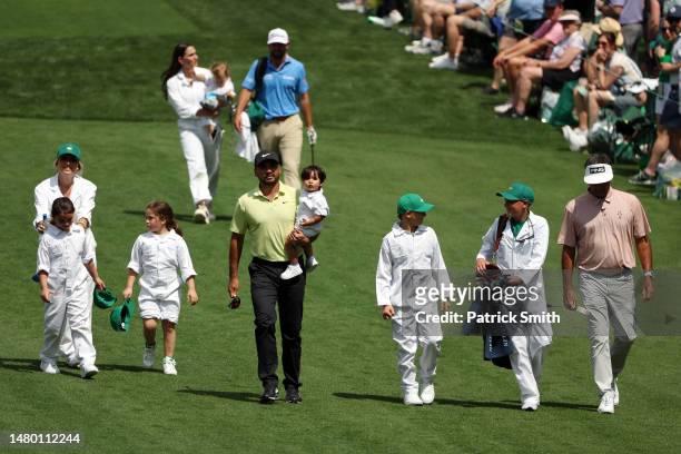 Jason Day of Australia and Bubba Watson of the United States walk up the second fairway with their families during the Par 3 contest prior to the...