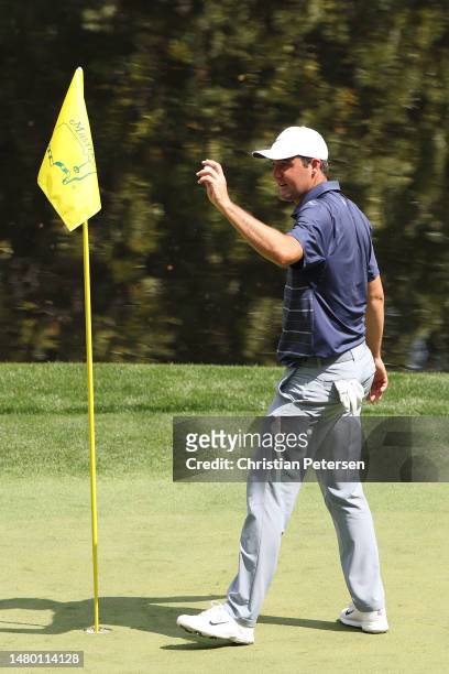 Scottie Scheffler of the United States reacts to his hole-in-one on the ninth green during the Par 3 contest prior to the 2023 Masters Tournament at...