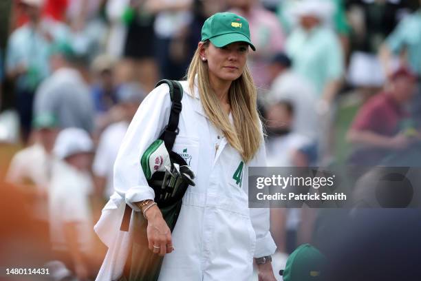 Rory McIlroy of Northern Ireland wife, Erica Stoll, looks on on the first hole during the Par 3 contest prior to the 2023 Masters Tournament at...