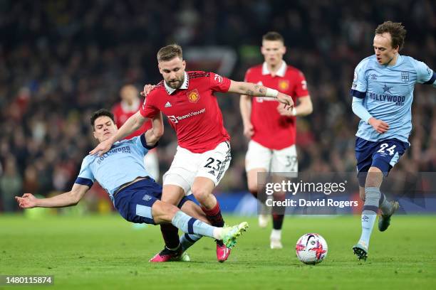 Luke Shaw of Manchester United is tackled by Christian Norgaard of Brentford during the Premier League match between Manchester United and Brentford...