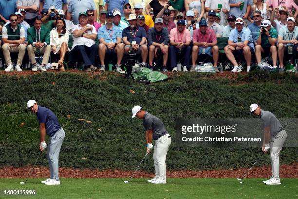 Scottie Scheffler of the United States, Tom Kim of South Korea and Sam Burns of the United States play their shot from the ninth tee during the Par 3...