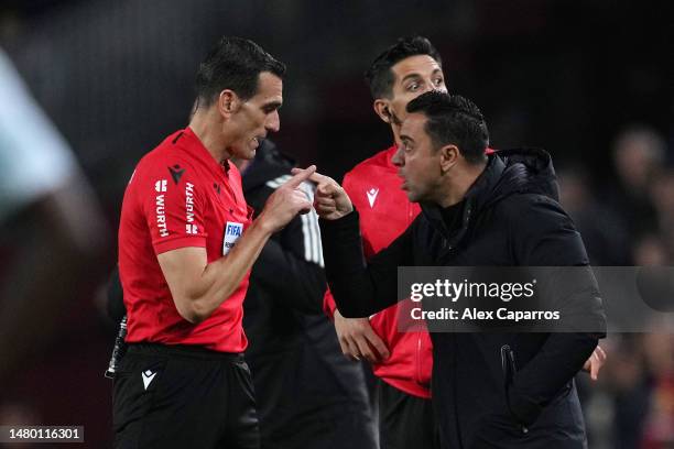 Xavi, Head Coach of FC Barcelona clashes with Referee Jose Munuera Montero after receiving a yellow card during the Copa Del Rey Semi Final Second...