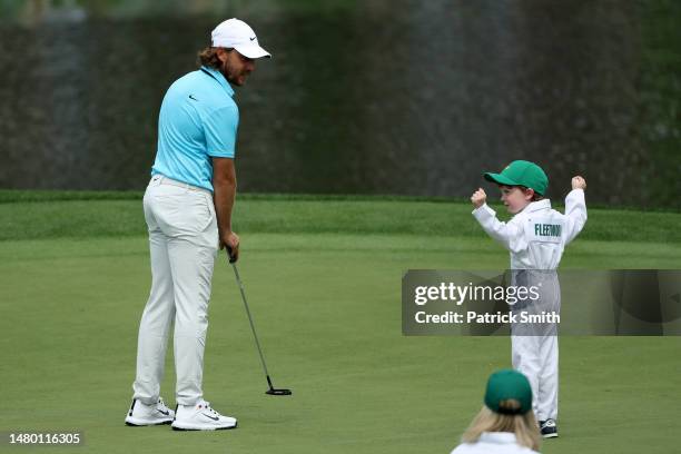 Tommy Fleetwood of England reacts on the first green with his son, Franklin, during the Par 3 contest prior to the 2023 Masters Tournament at Augusta...