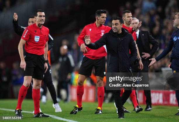 Xavi, Head Coach of FC Barcelona clashes with Referee Jose Munuera Montero after receiving a yellow card during the Copa Del Rey Semi Final Second...