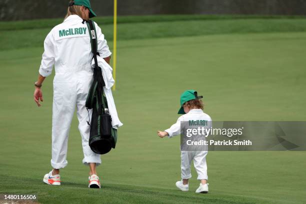 Rory McIlroy of Northern Ireland wife, Erica Stoll, walks on the first green with their daughter Poppy McIlroy on the first hole during the Par 3...