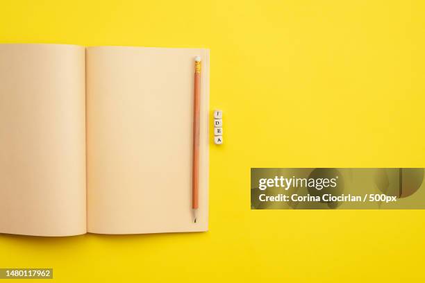 open empty diary with a pencil and an inscription idea on yellow background,romania - open romania imagens e fotografias de stock