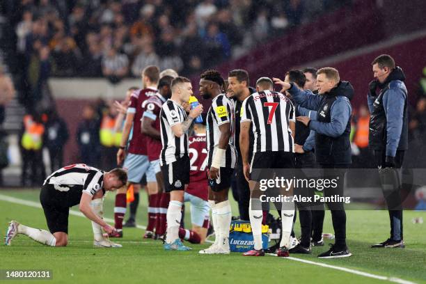 Players of West Ham United and Newcastle United pause during play to eat during the Premier League match between West Ham United and Newcastle United...