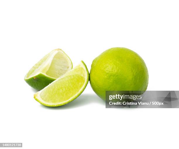 lime with slice isolated on white background,close up,romania - limone stock-fotos und bilder