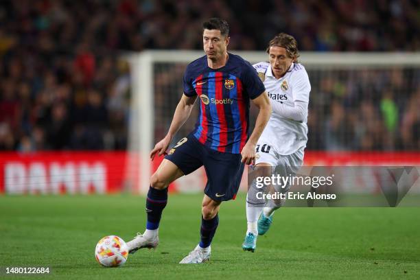 Robert Lewandowski of FC Barcelona runs with the ball whilst under pressure from Luka Modric of Real Madrid during the Copa Del Rey Semi Final Second...