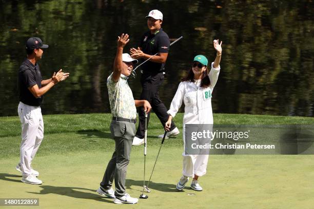 Si Woo Kim of South Korea and his wife, Ji Hyun Oh, celebrate a putt on the ninth green during the Par 3 contest prior to the 2023 Masters Tournament...