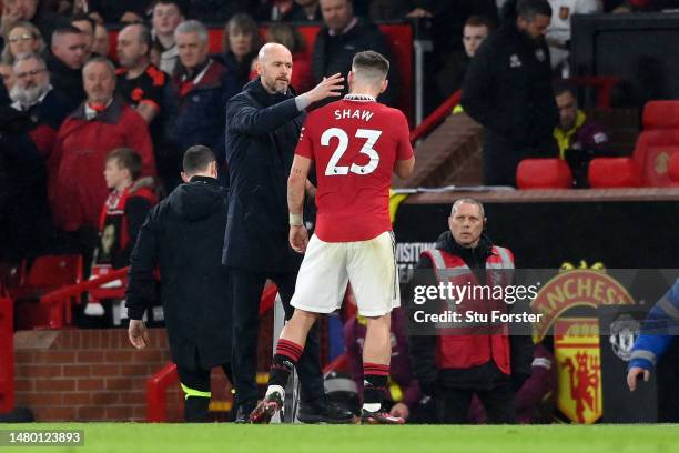 Erik ten Hag, Manager of Manchester United, interacts with Luke Shaw after being substituted off during the Premier League match between Manchester...