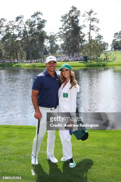 Brooks Koepka of the United States poses for a photo with his wife, Jena Sims Koepka, during the Par 3 contest prior to the 2023 Masters Tournament...
