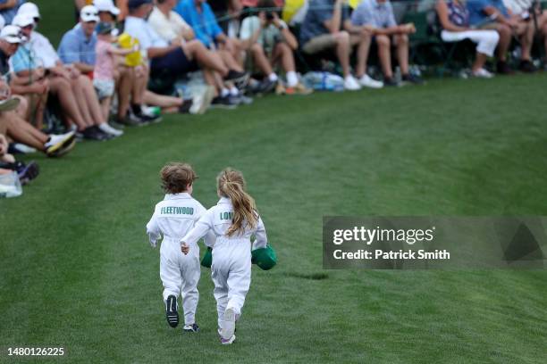 Franklin Fleetwood and Iris Lowry run up the fairway during the Par 3 contest prior to the 2023 Masters Tournament at Augusta National Golf Club on...