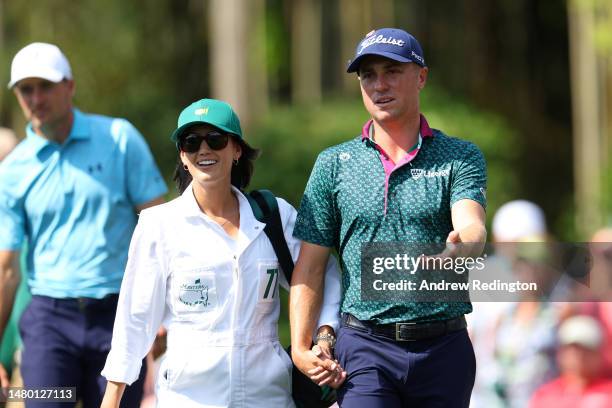 Justin Thomas of the United States walks with his wife Jillian Thomas during the Par 3 contest prior to the 2023 Masters Tournament at Augusta...