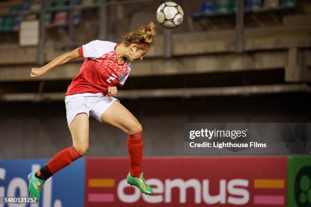 a female winger meets a header in mid air for a shot on goal - pursuit sports competition format stock pictures, royalty-free photos & images