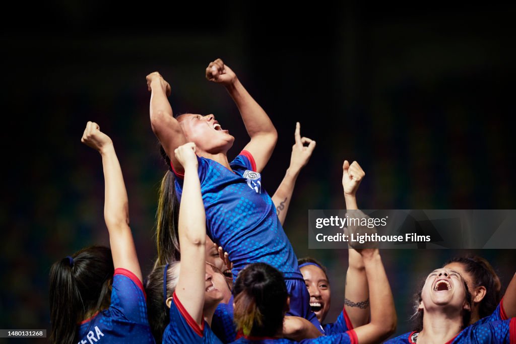 Overjoyed team of women football players rejoice after winning a compeition