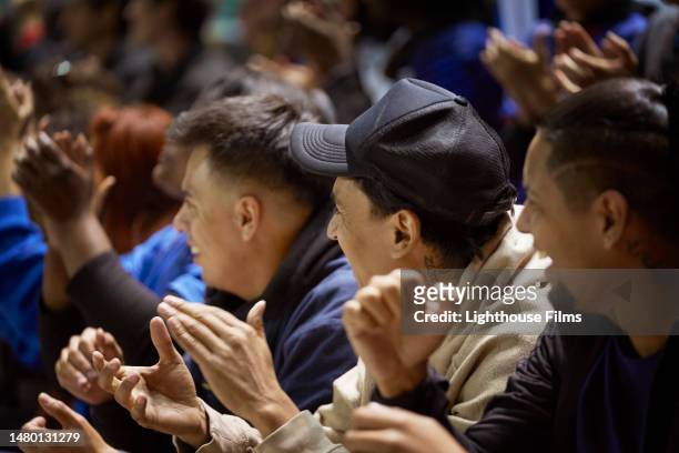 a group of three men in a crowd cheer on a sports team - small group of people stock-fotos und bilder